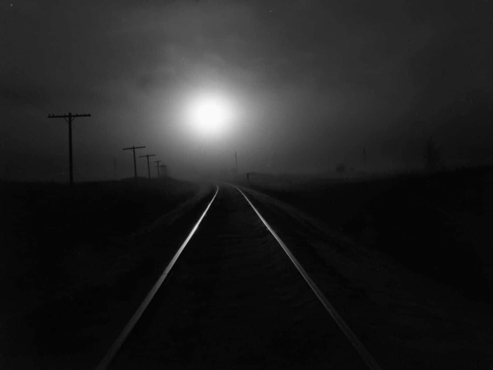 Download A Black And White Photo Of A Train Track In The Fog Wallpaper