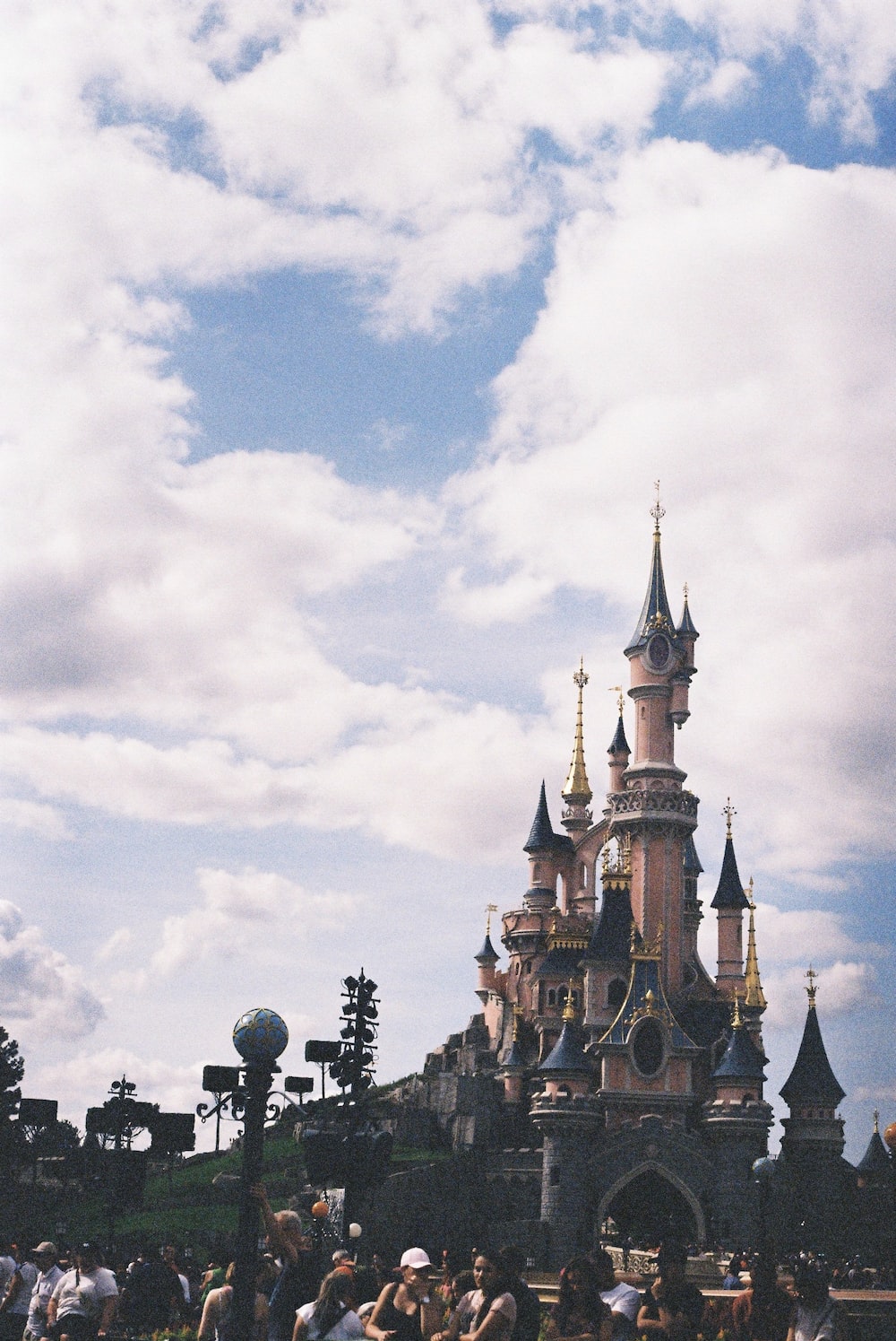 Pink and blue Disneyland castle under white and blue cloudy sky photo