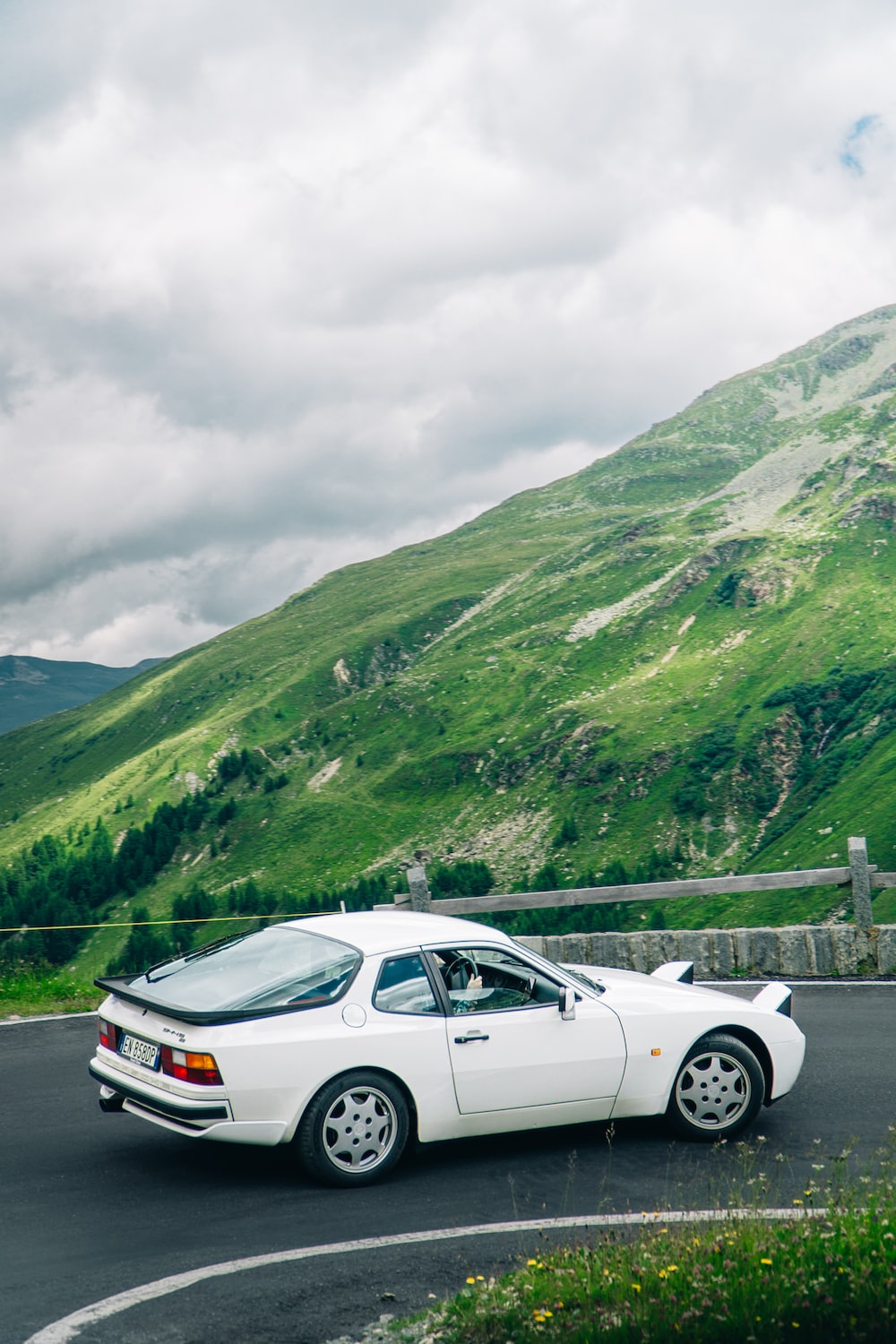 A white car parked on a road with a mountain in the background photo