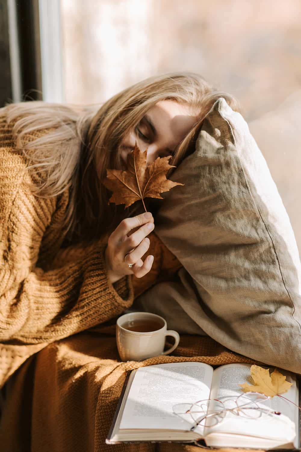 Download Cozy Lady Sniffing Autumn Leaf Aesthetic Wallpaper