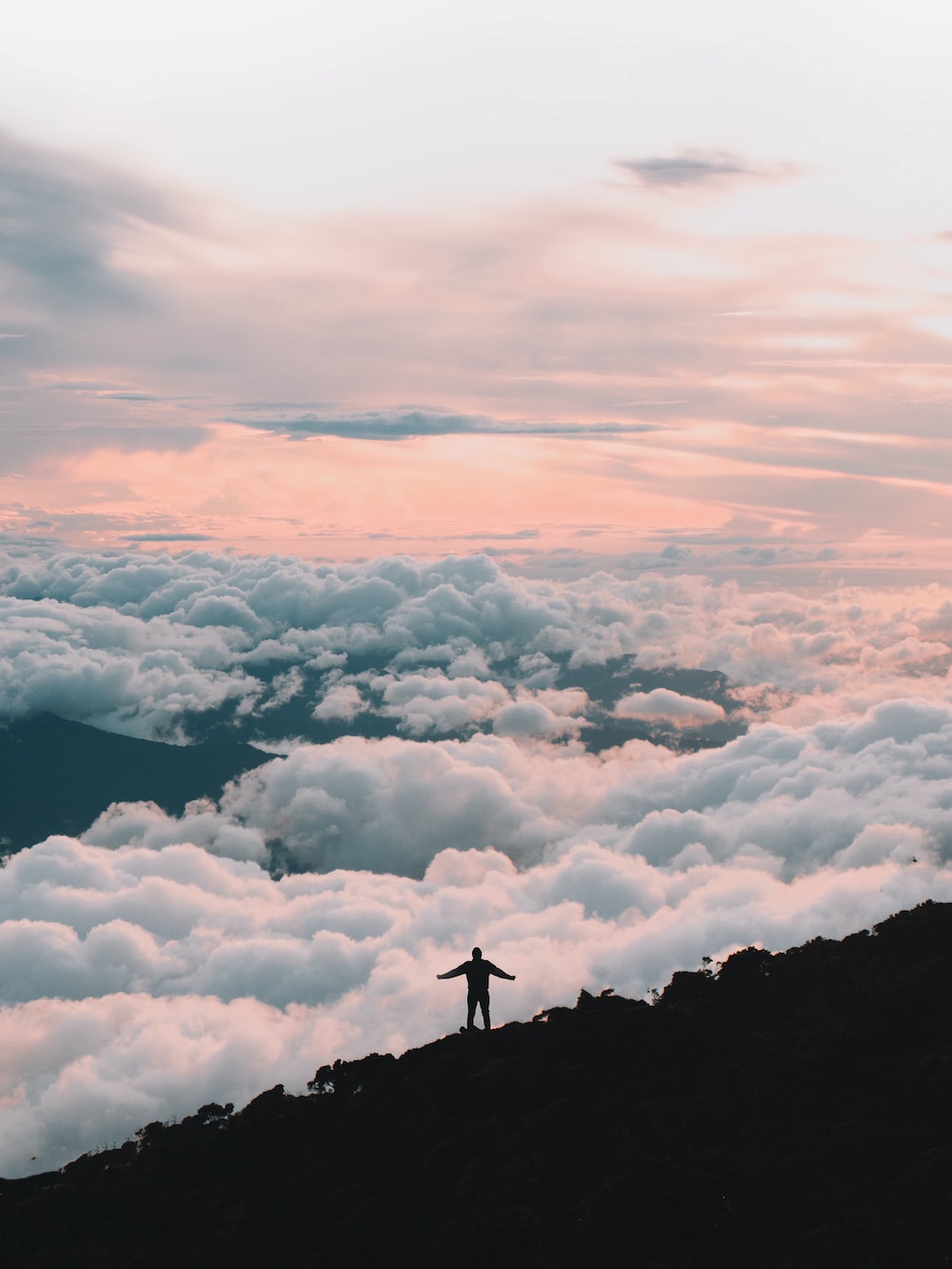 Person standing on top of mountain during daytime photo