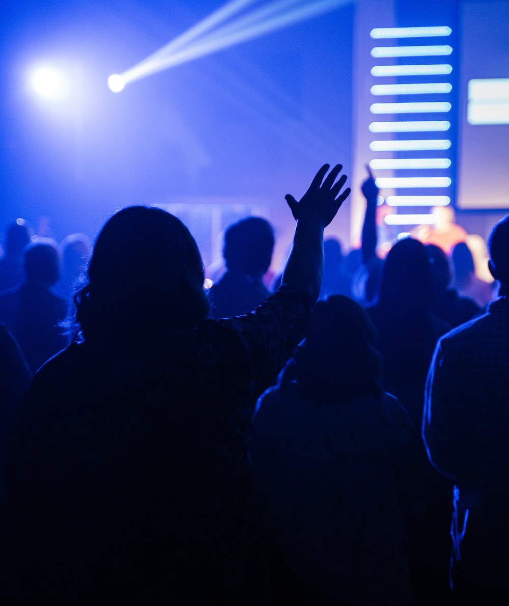 People raising their hands in front of stage photo