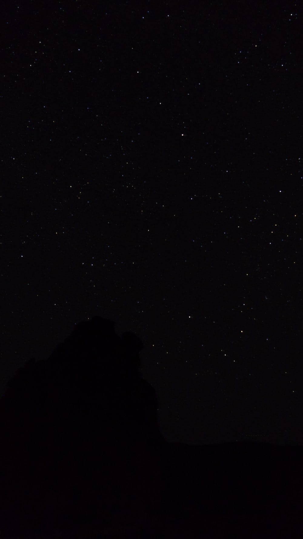 The night sky with stars above a mountain photo