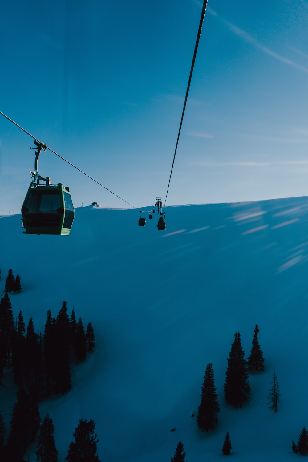 A ski lift going up a snowy mountain photo