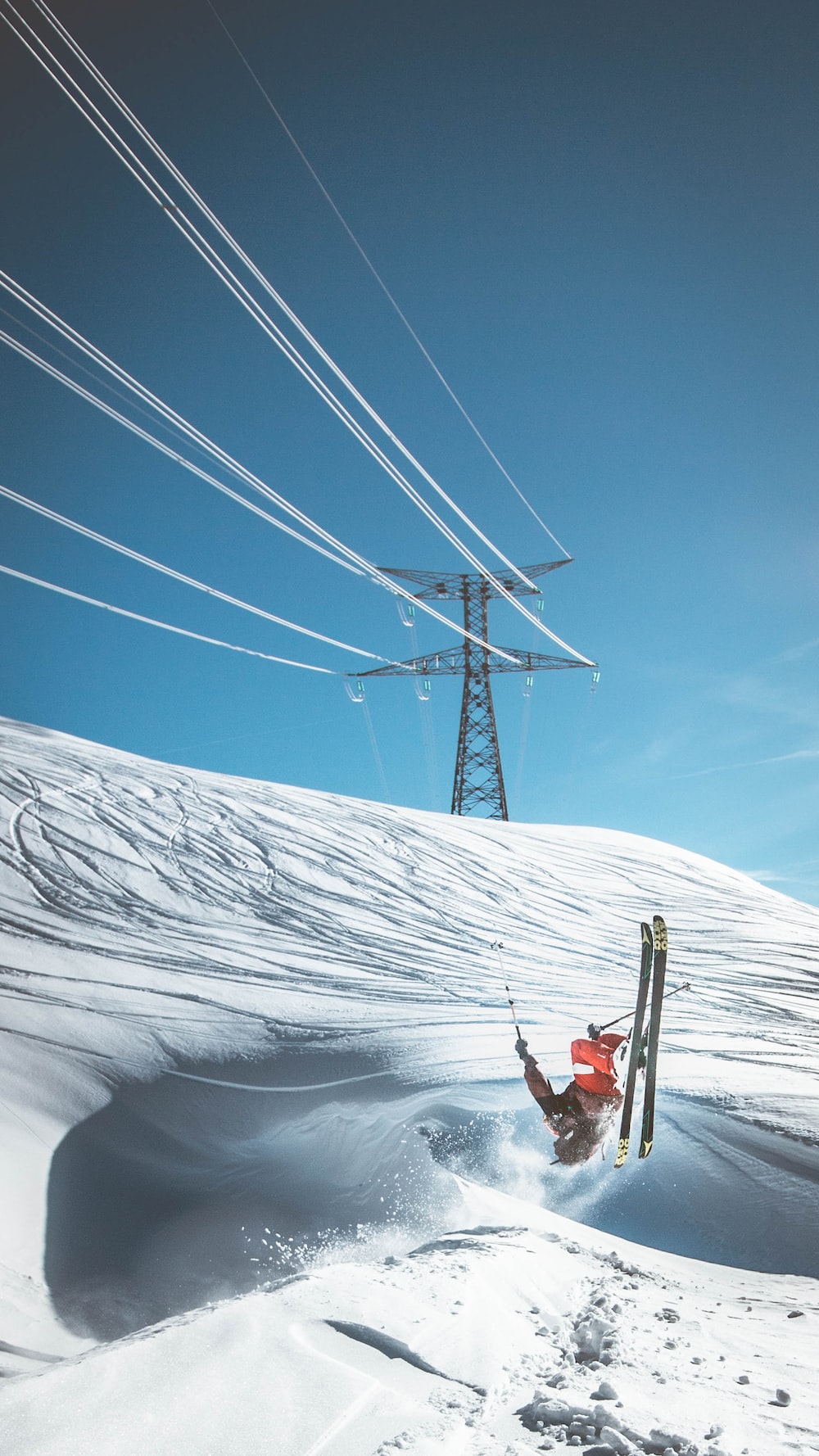 Man skiing on snow near electric tower photo