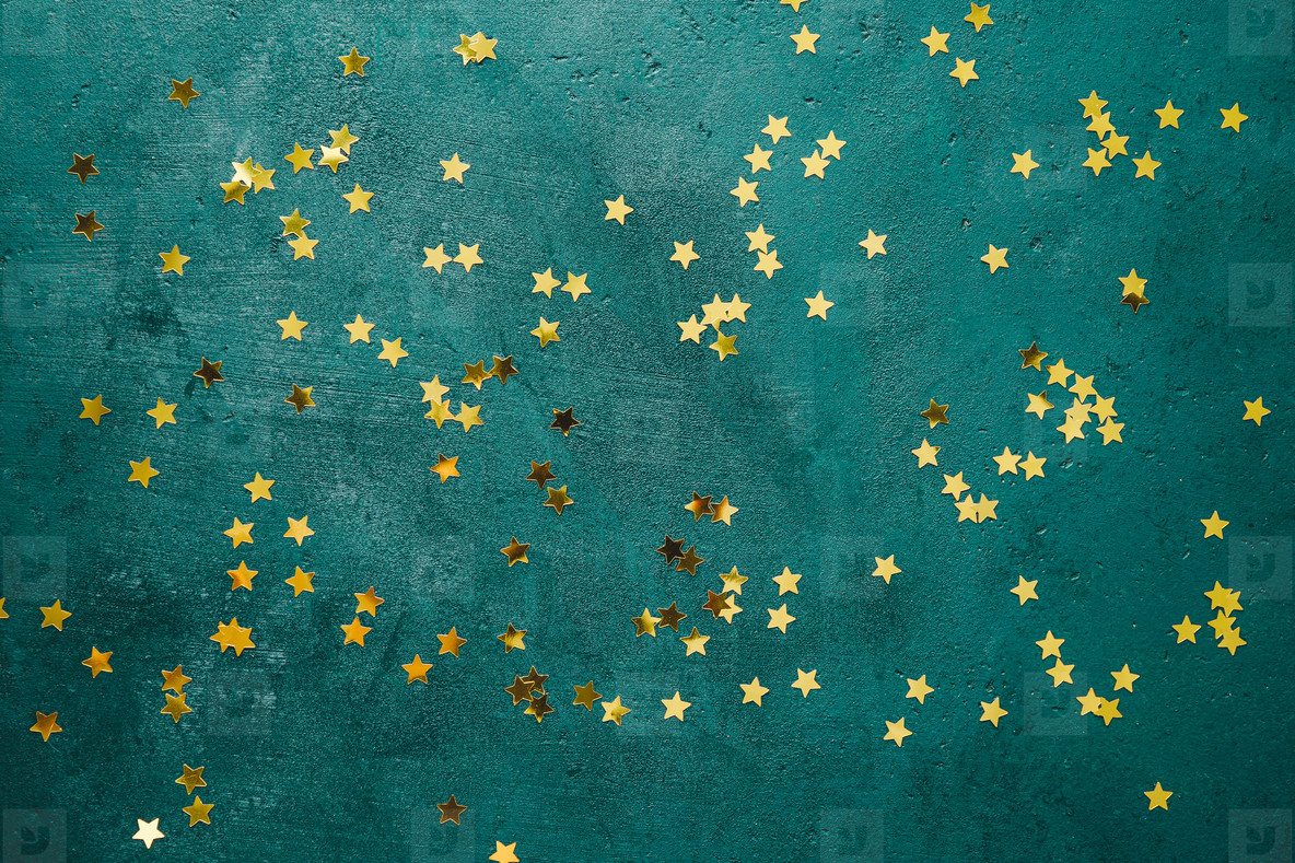 The New Year or Christmas festive flat lay with golden stars over a dark green background. Top view