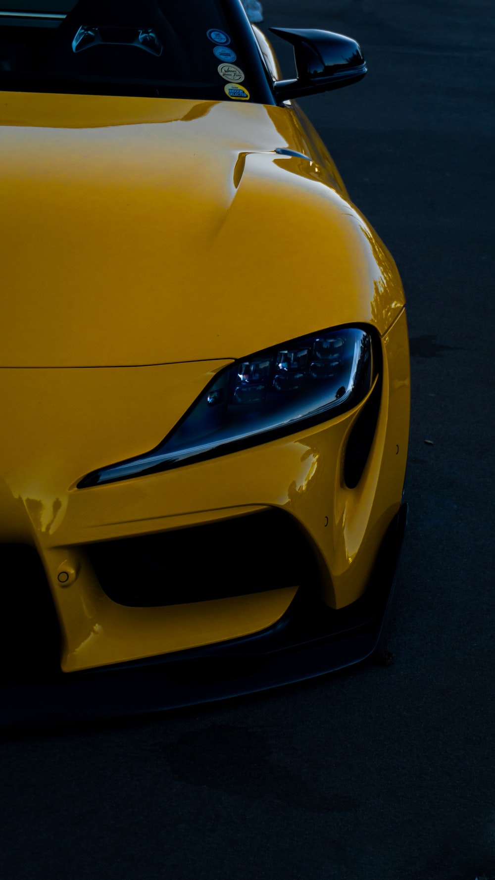 A yellow sports car parked in a parking lot photo