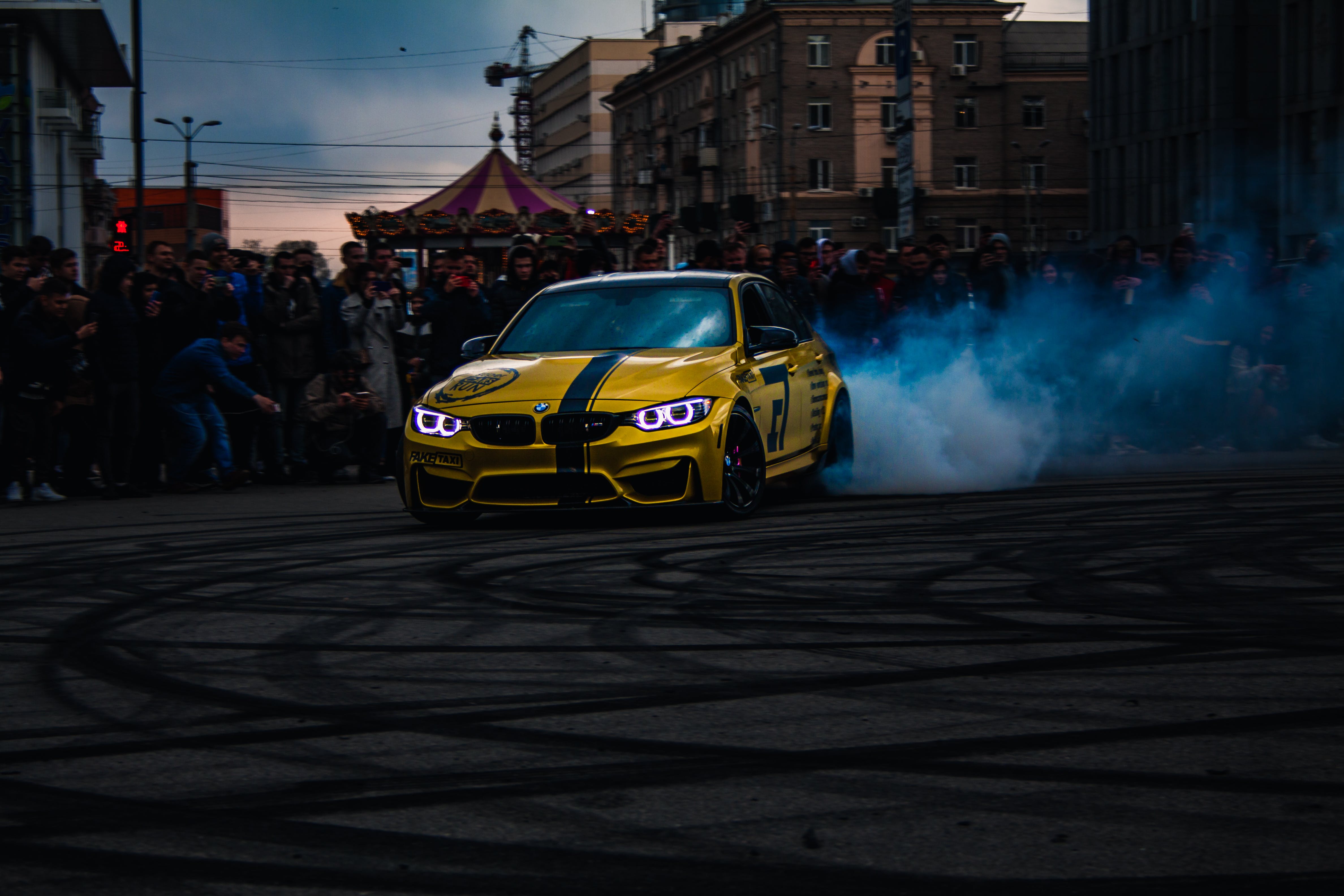 A Yellow BMW Drifting in front of the Crowd · Free