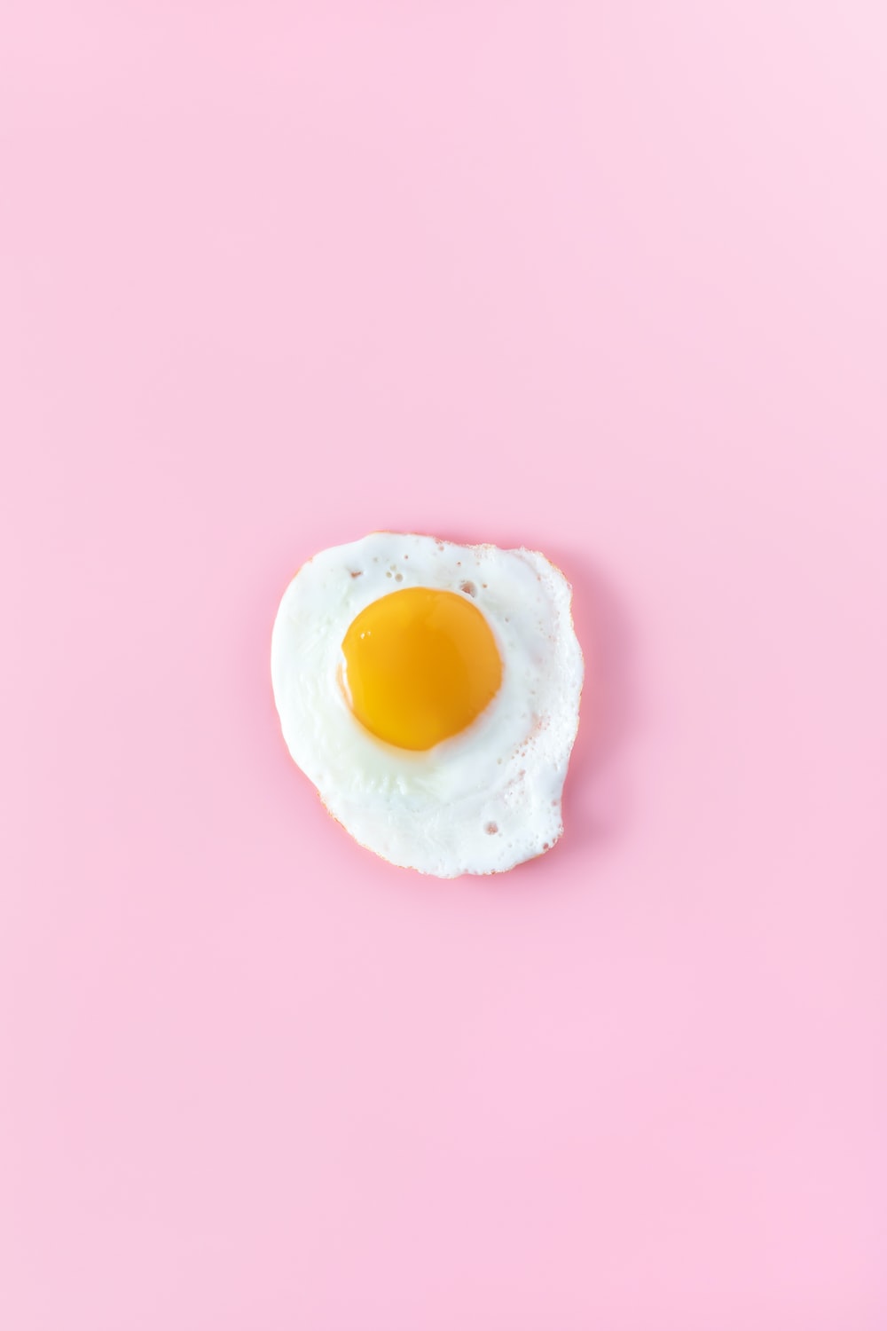 Sunny side up egg on pink surface photo