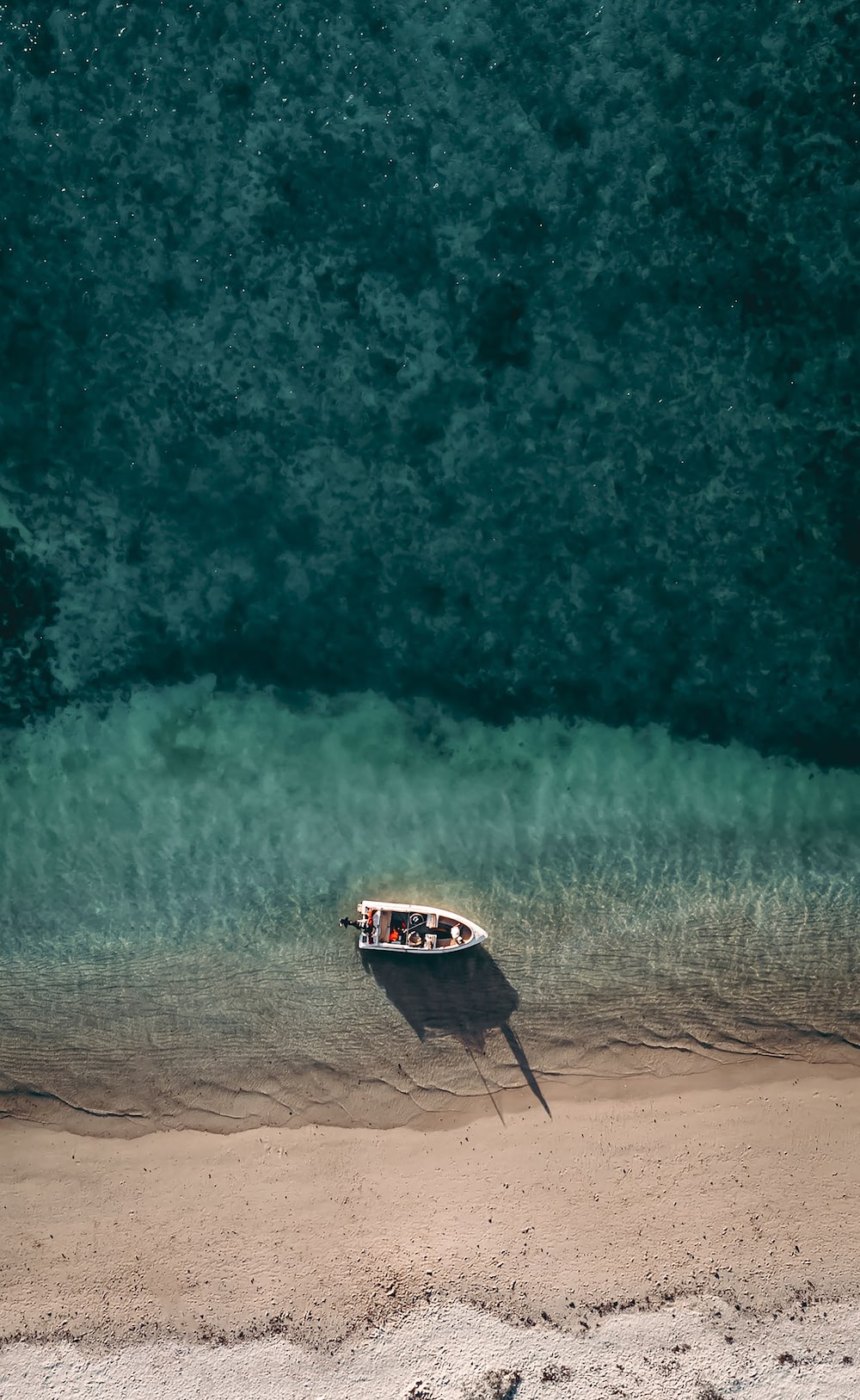 A small boat on the shore of a beach photo