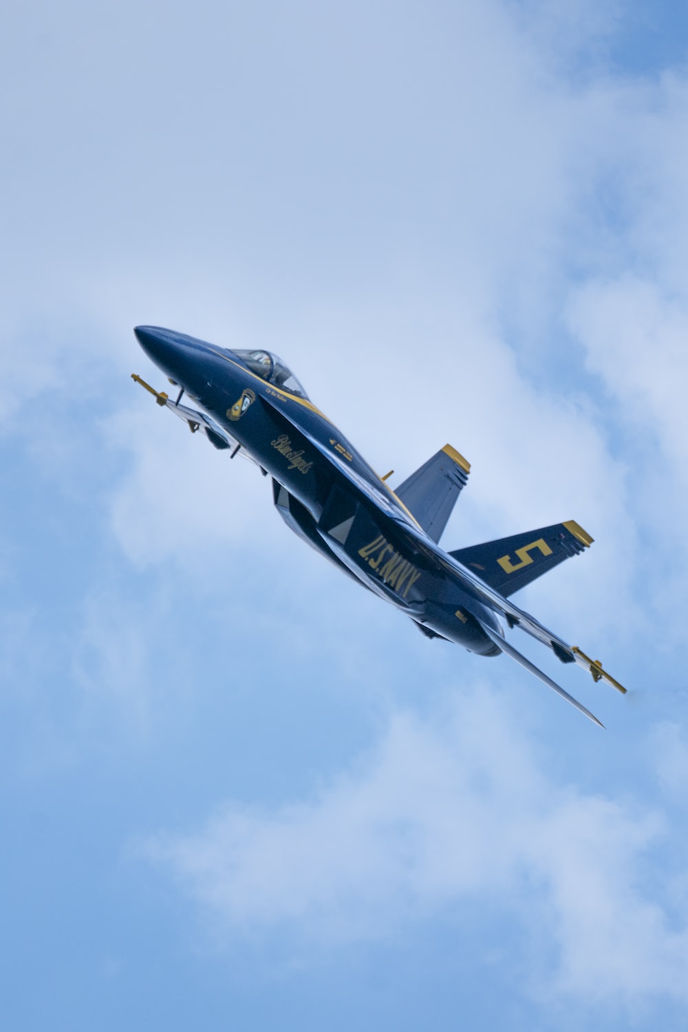 A fighter jet flying through a cloudy blue sky photo