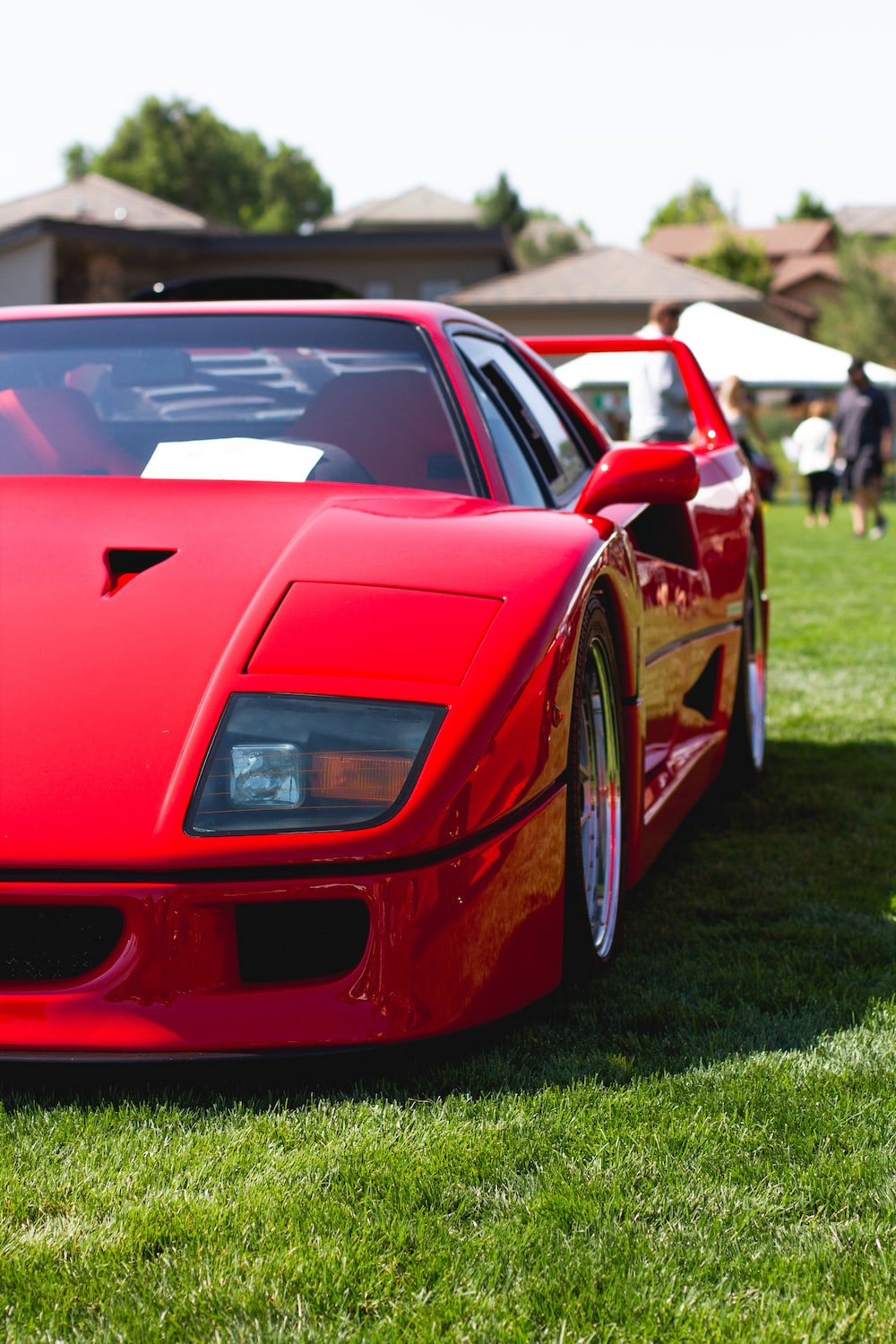 Red ferrari 458 italia on green grass field during daytime photo