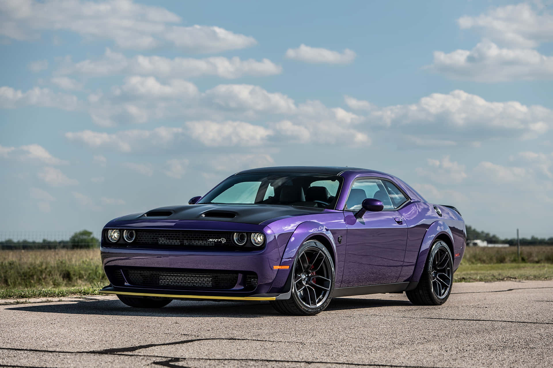 Download A Purple Dodge Challenger Srt Parked On A Road Wallpaper