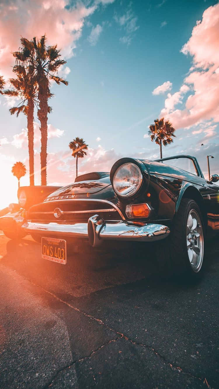 Download A Spectacular Vintage Car Sitting Next To An iPhone Wallpaper