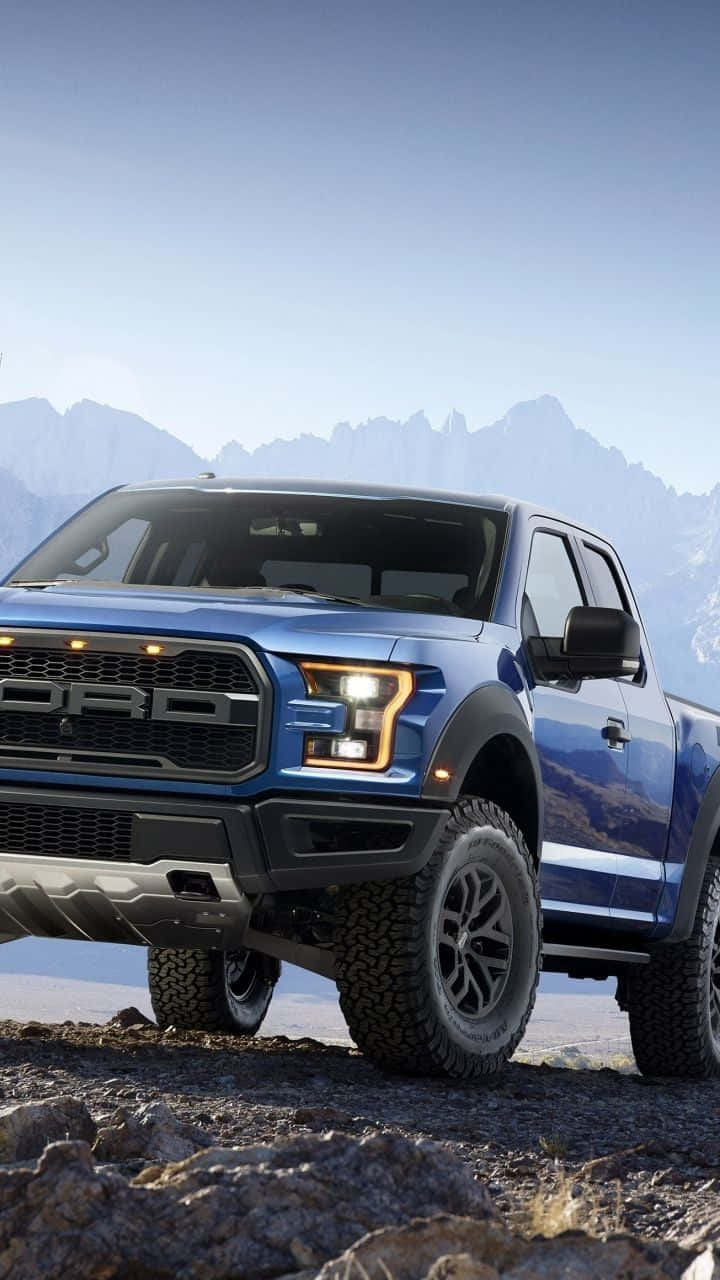Download The Blue Ford F Raptor Is Parked On A Rocky Mountain Wallpaper