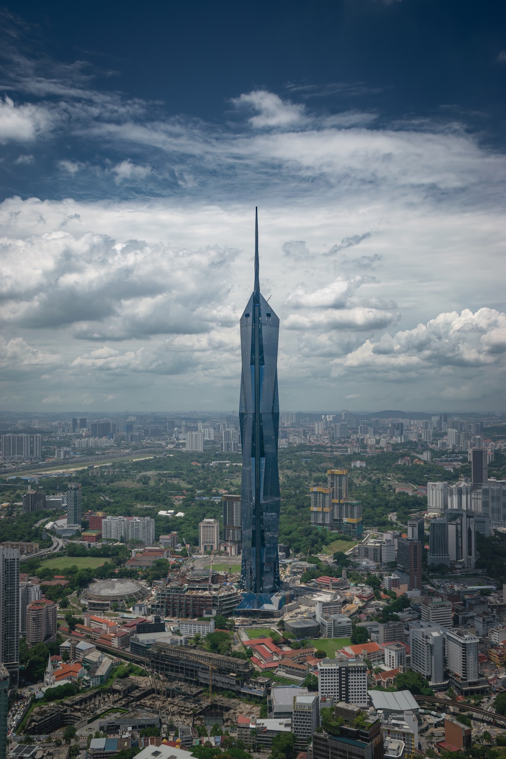 A tall building towering over a city under a cloudy sky photo