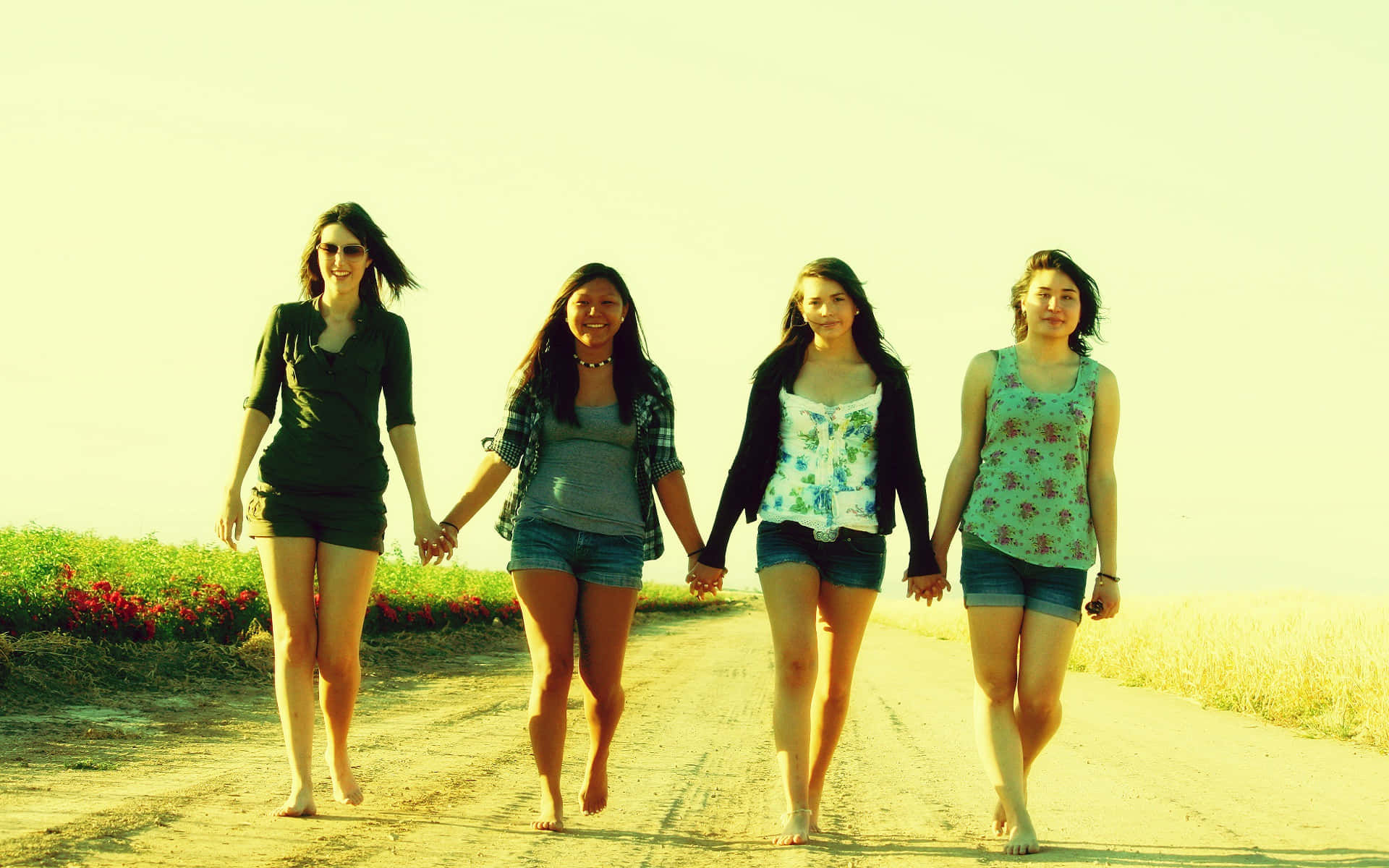 Download Four Girls Walking Down A Dirt Road