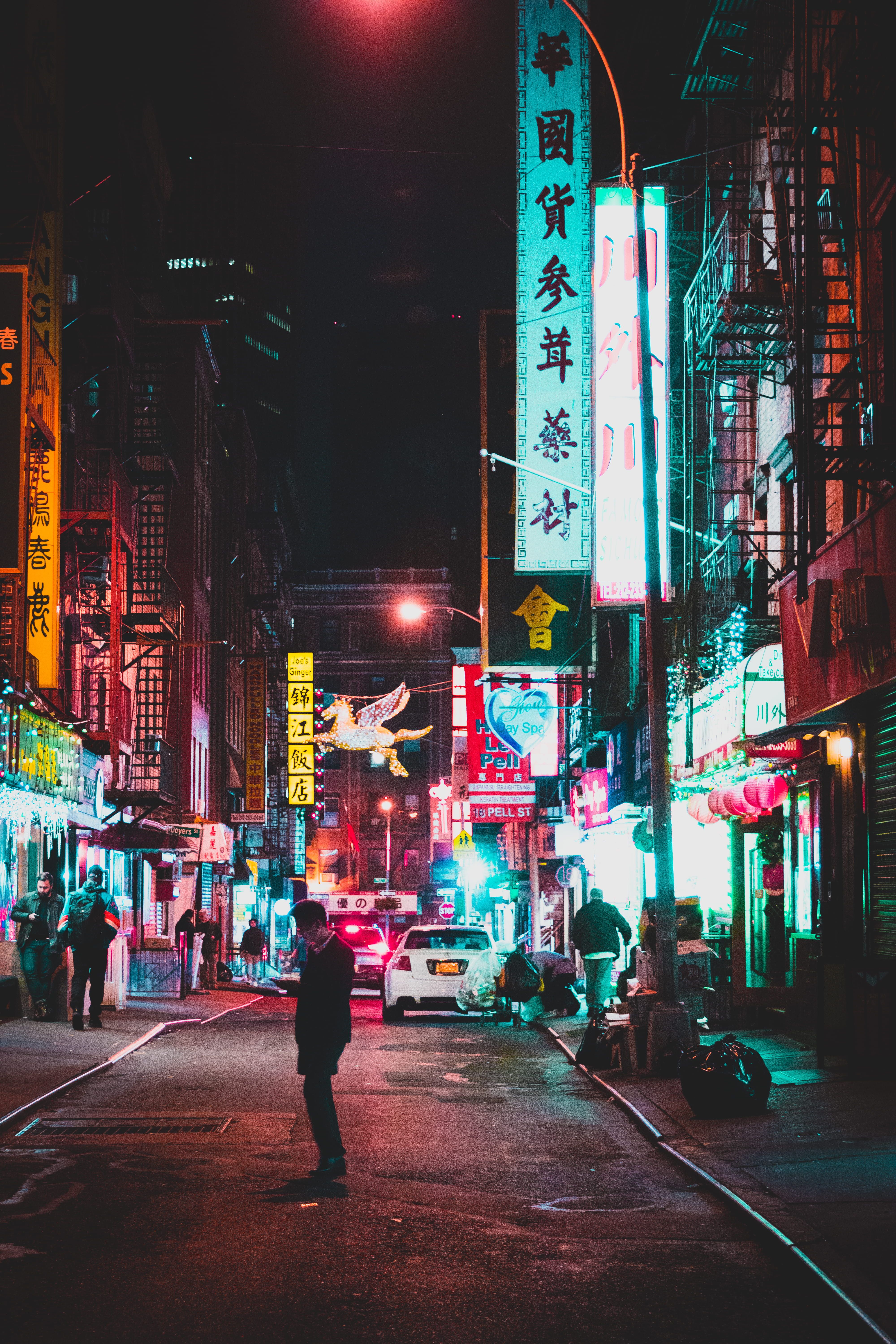 man standing on street between buildings with signages #art #glow #chinese #street street photography #light #neon. Signage, Grayscale, Rule of thirds photography
