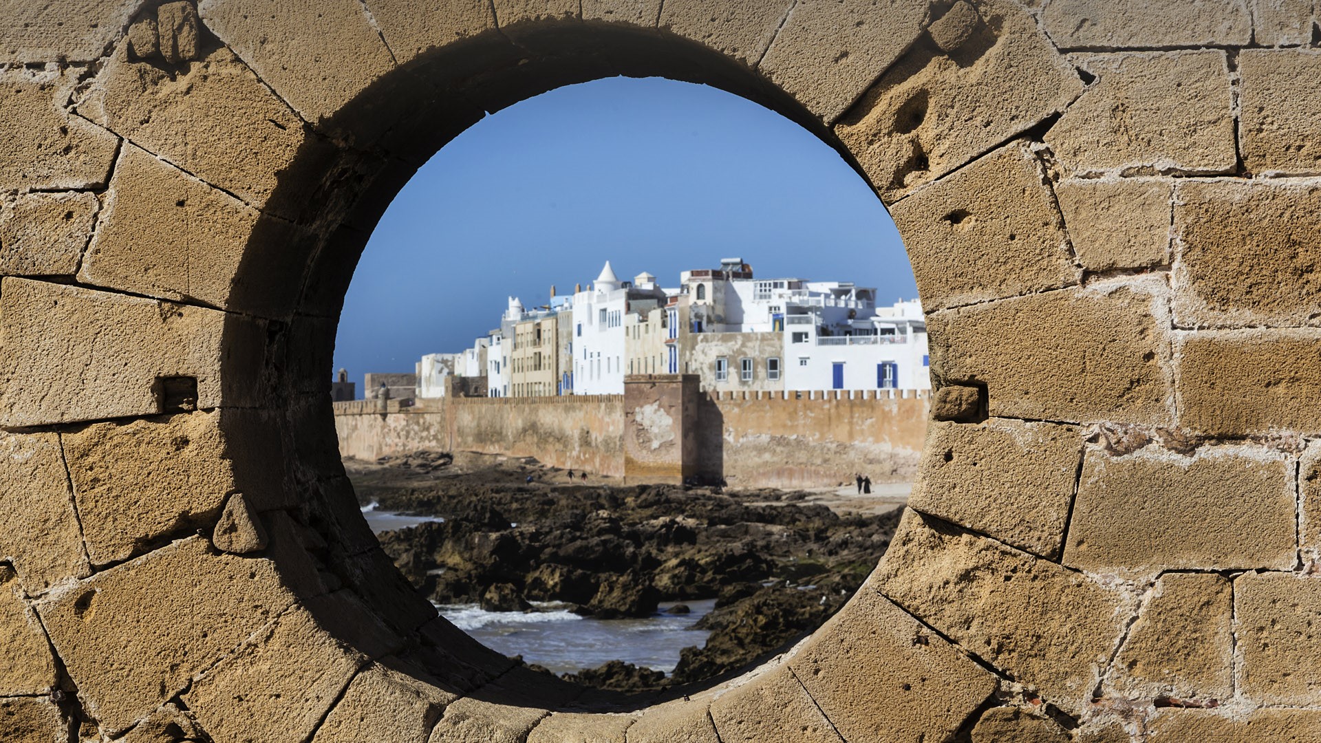 The fortified city of Essaouira view through hole in brick wall, Morocco. Windows Spotlight Image