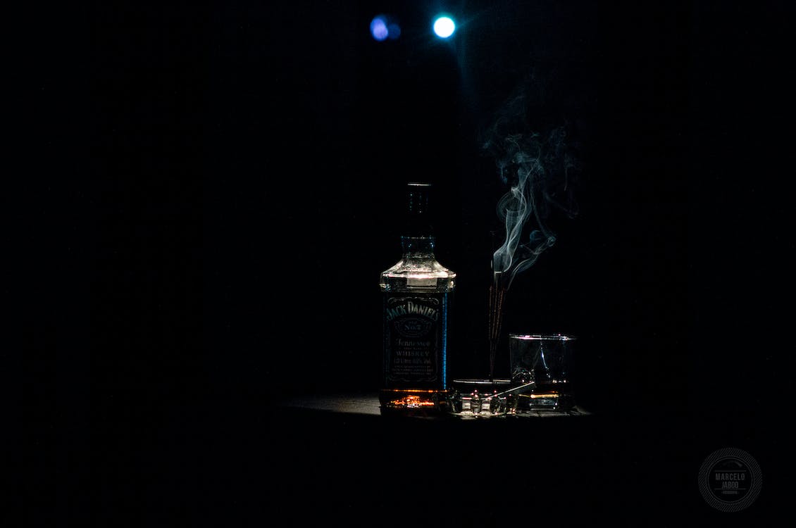 Closeup Photo of Liquor Bottle Against Black Background · Free