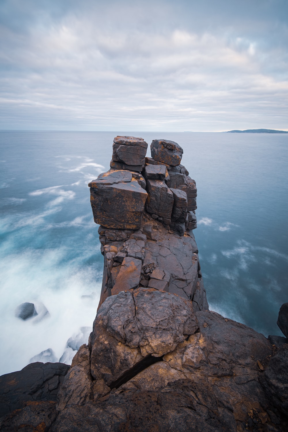 Brown rock formation on sea during daytime photo