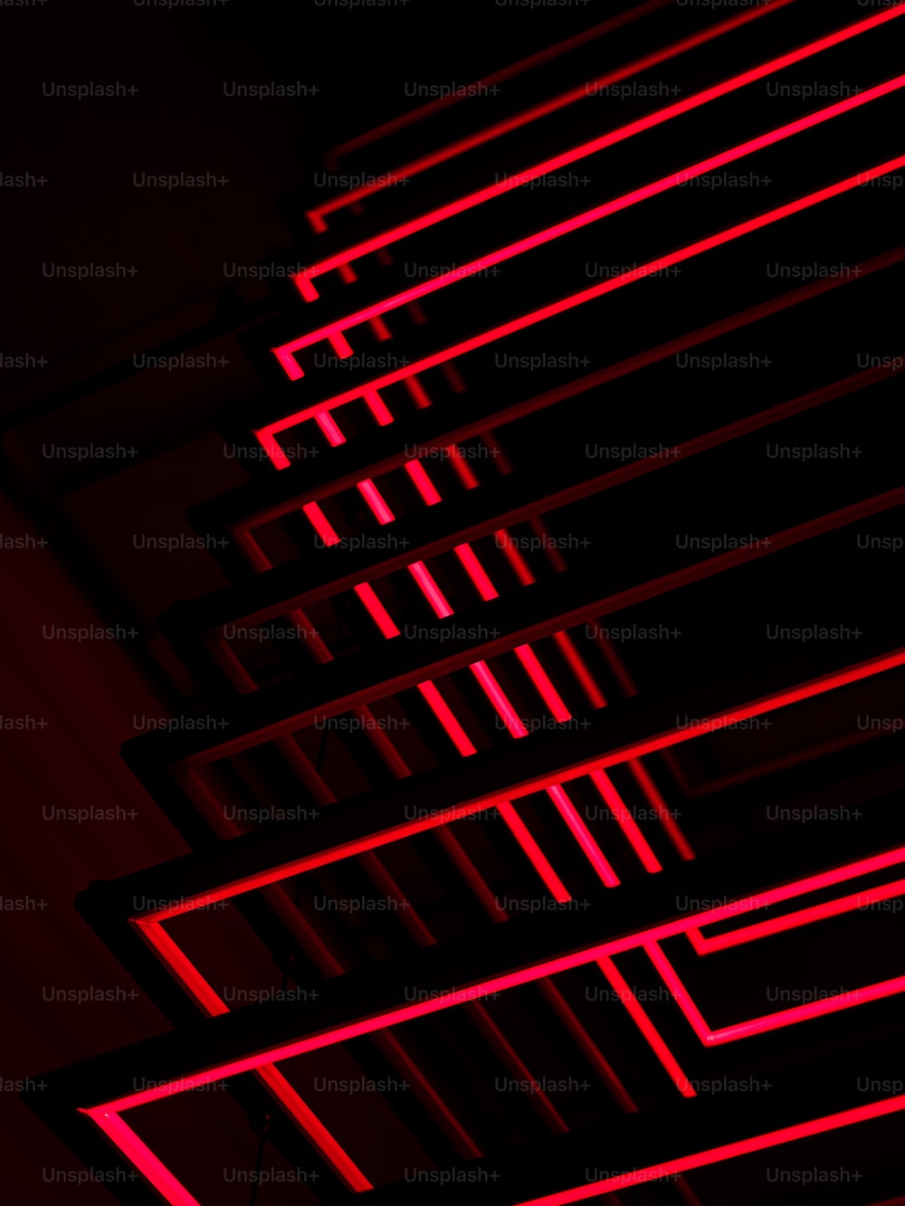 A row of red neon lights in a dark room photo