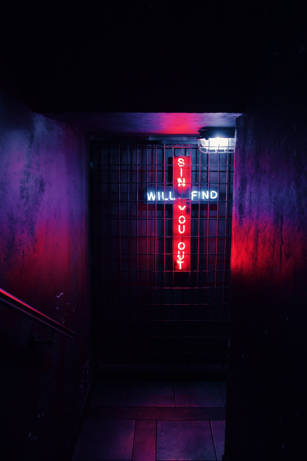 Red and white neon light wall decors on black metal fence photo