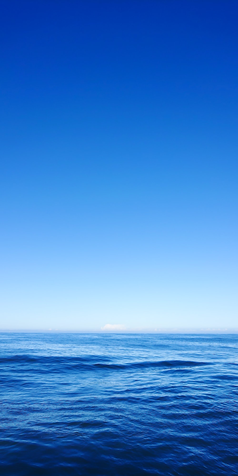 Ocean water under clear blue sky photo