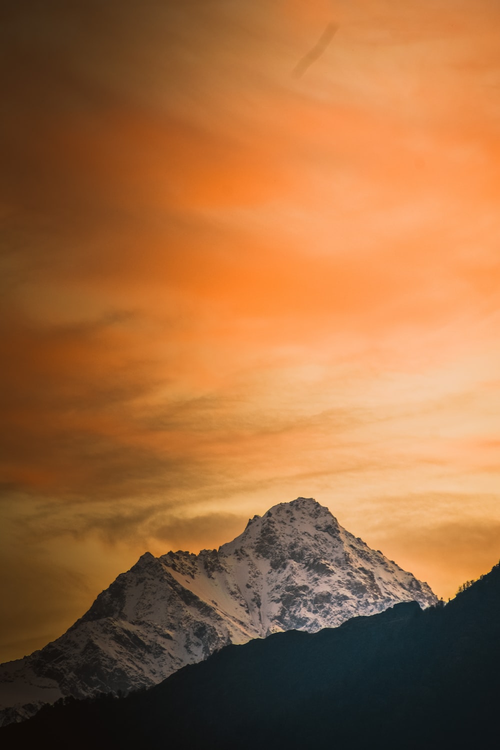 Mountain covered with snow under orange