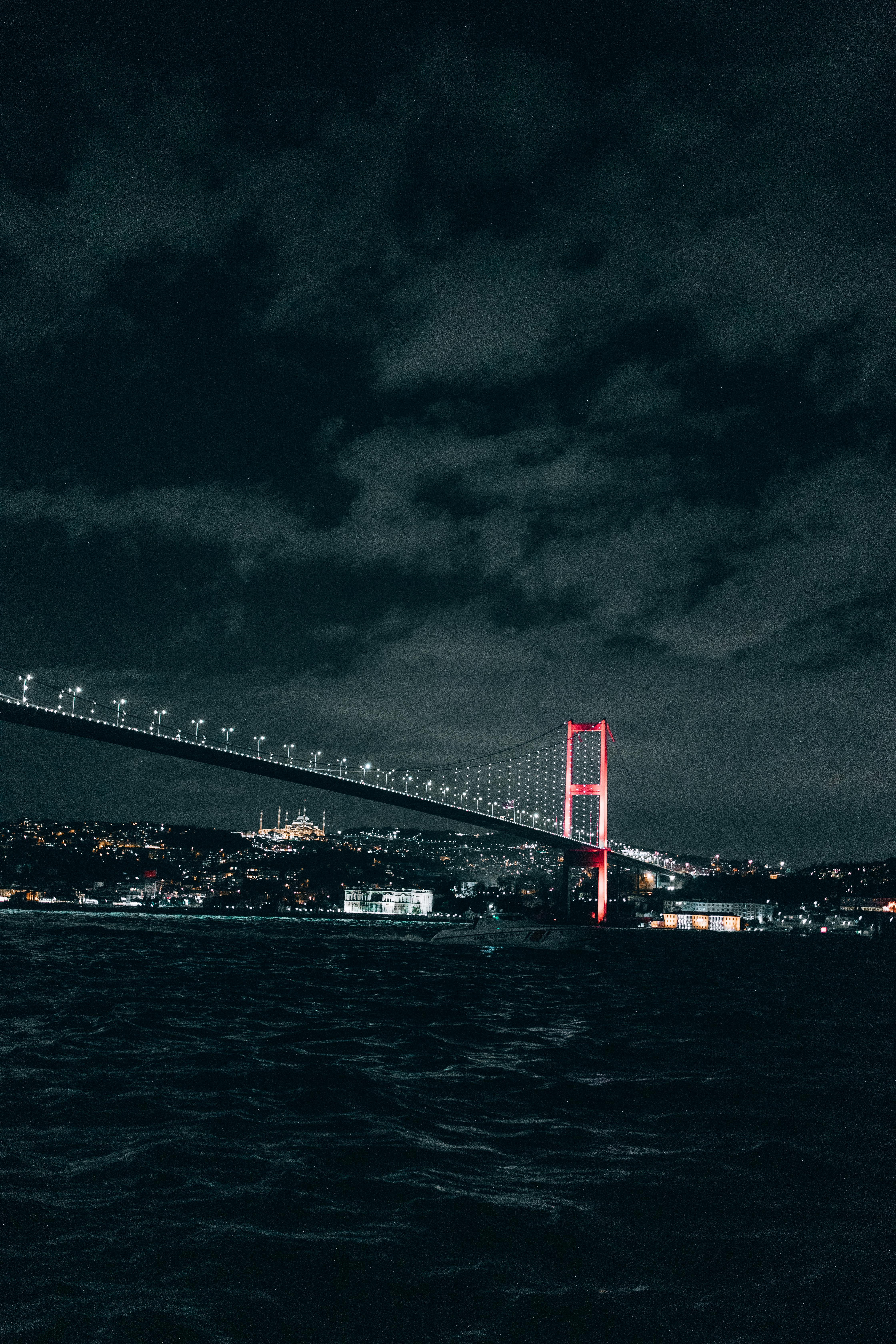 Illuminated Bridge above River at Night