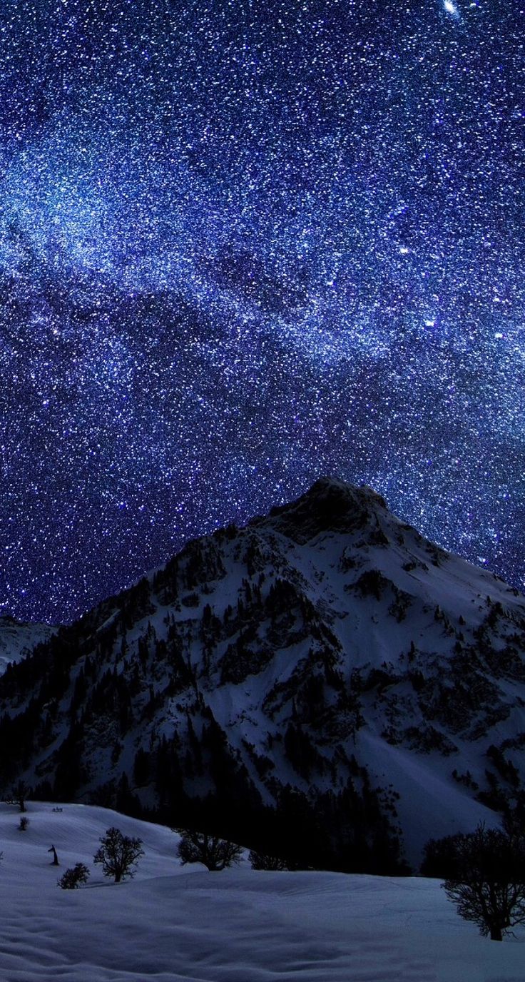 Very starry night over snowy mountain