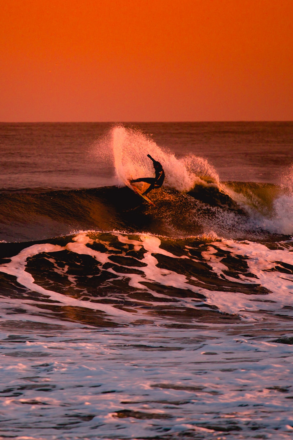 Person surfing during sunset photo