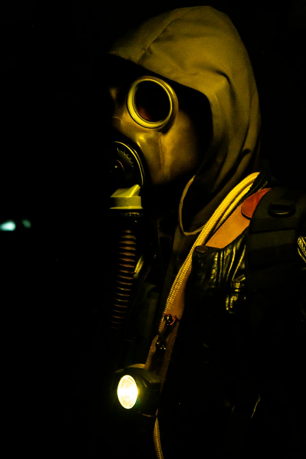 A man in a gas mask with a flashlight