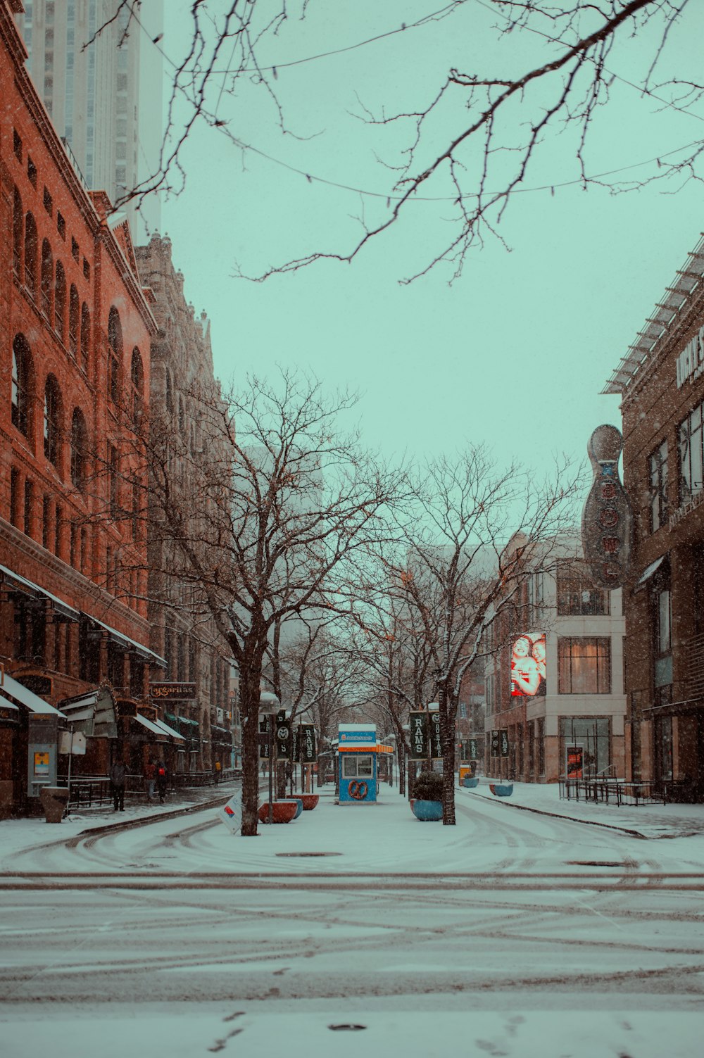 A snowy street with buildings on either