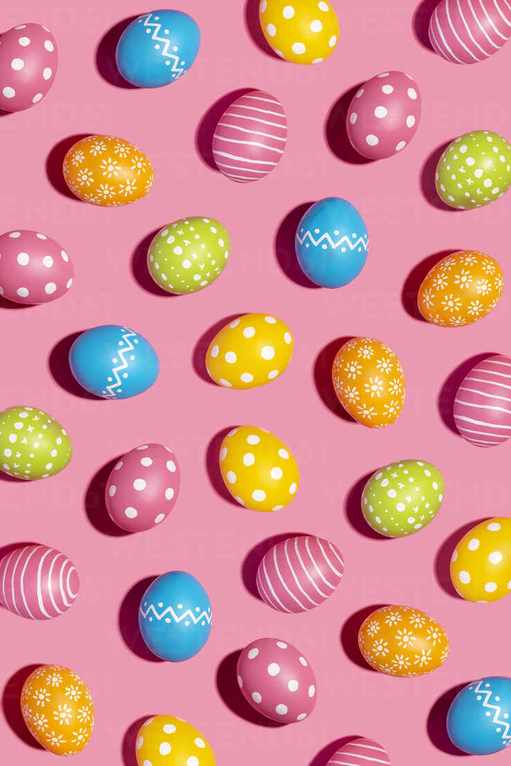 Colorful decorated Easter eggs on pink