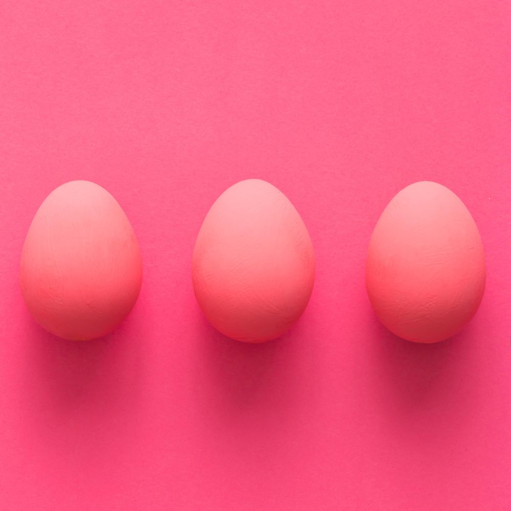 Row of three pink Easter eggs on pink
