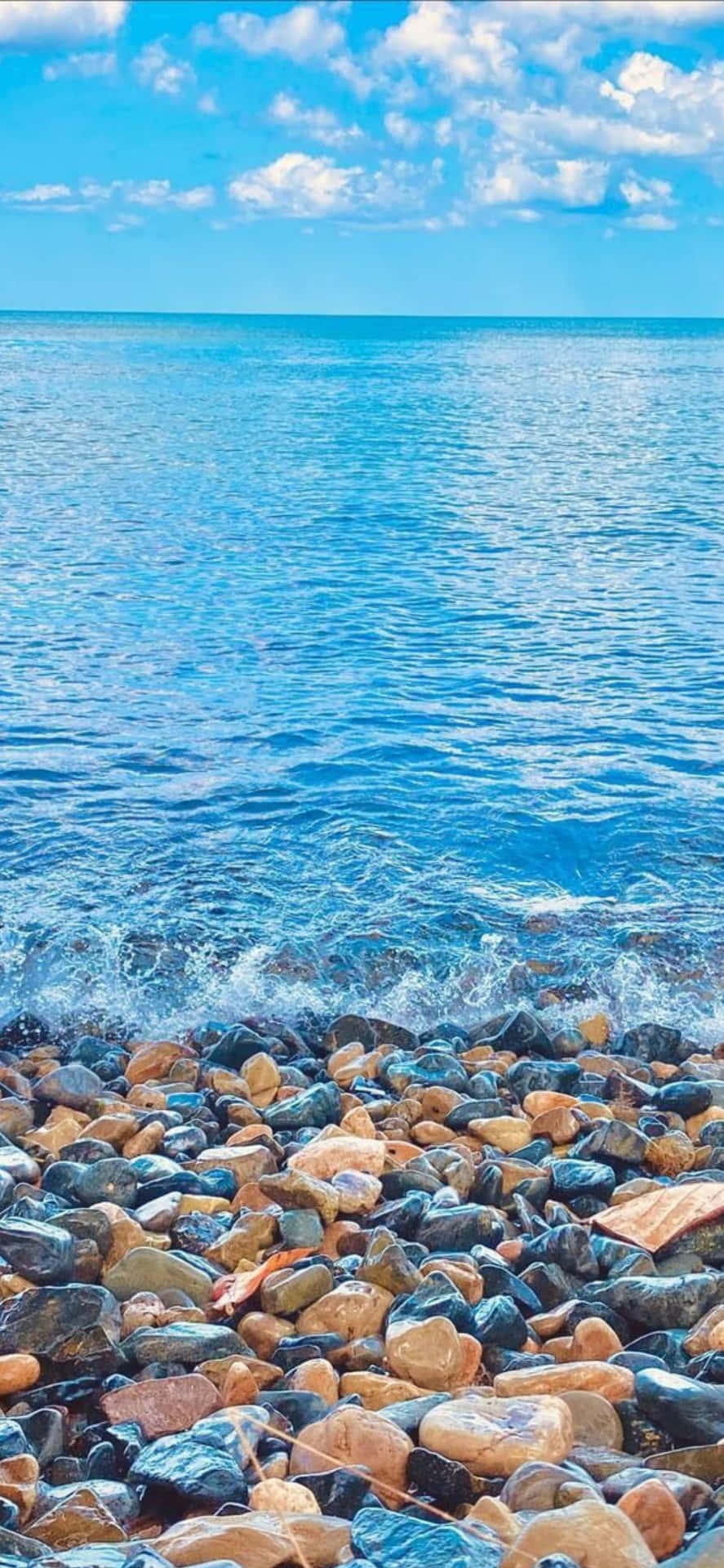 Download A Beach With Rocks And Water