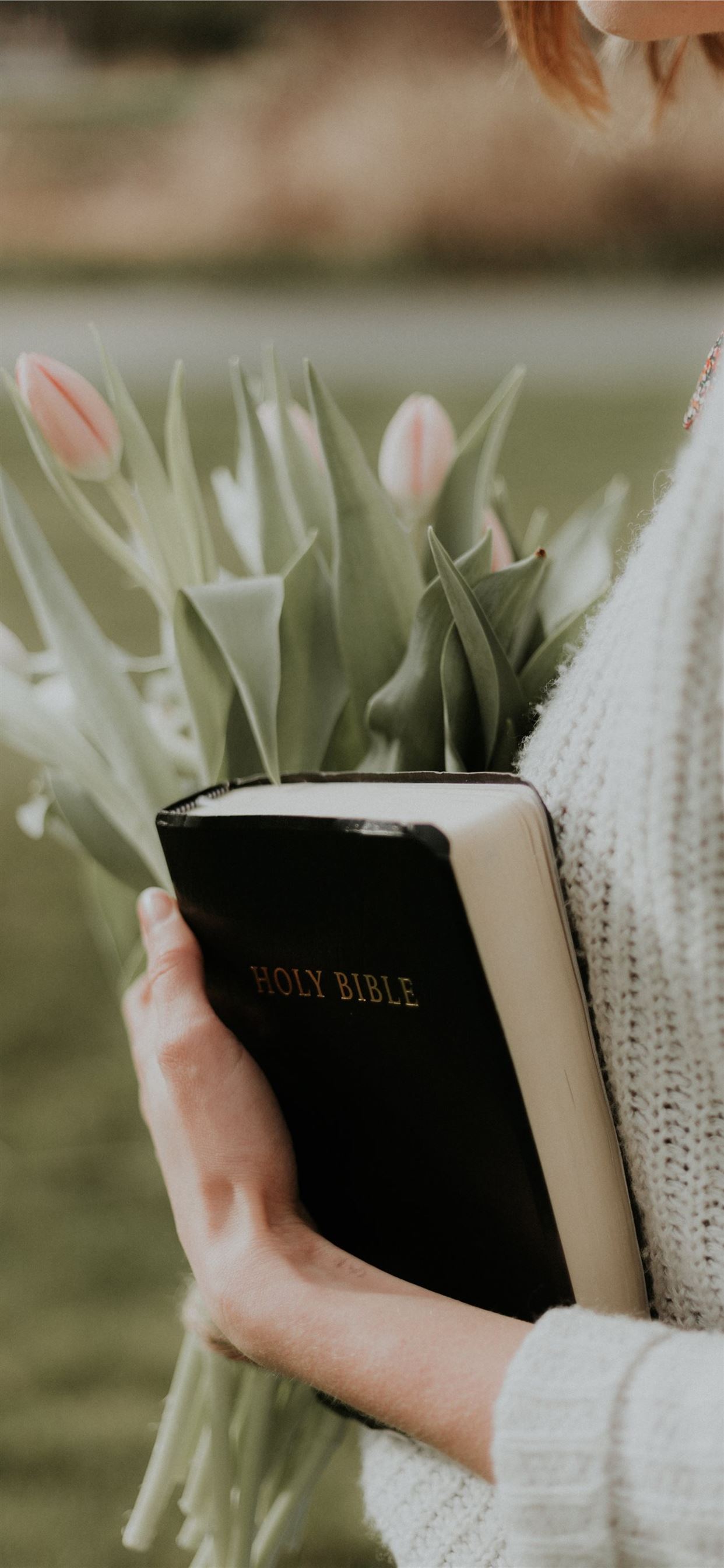 woman holding Holy Bible iPhone