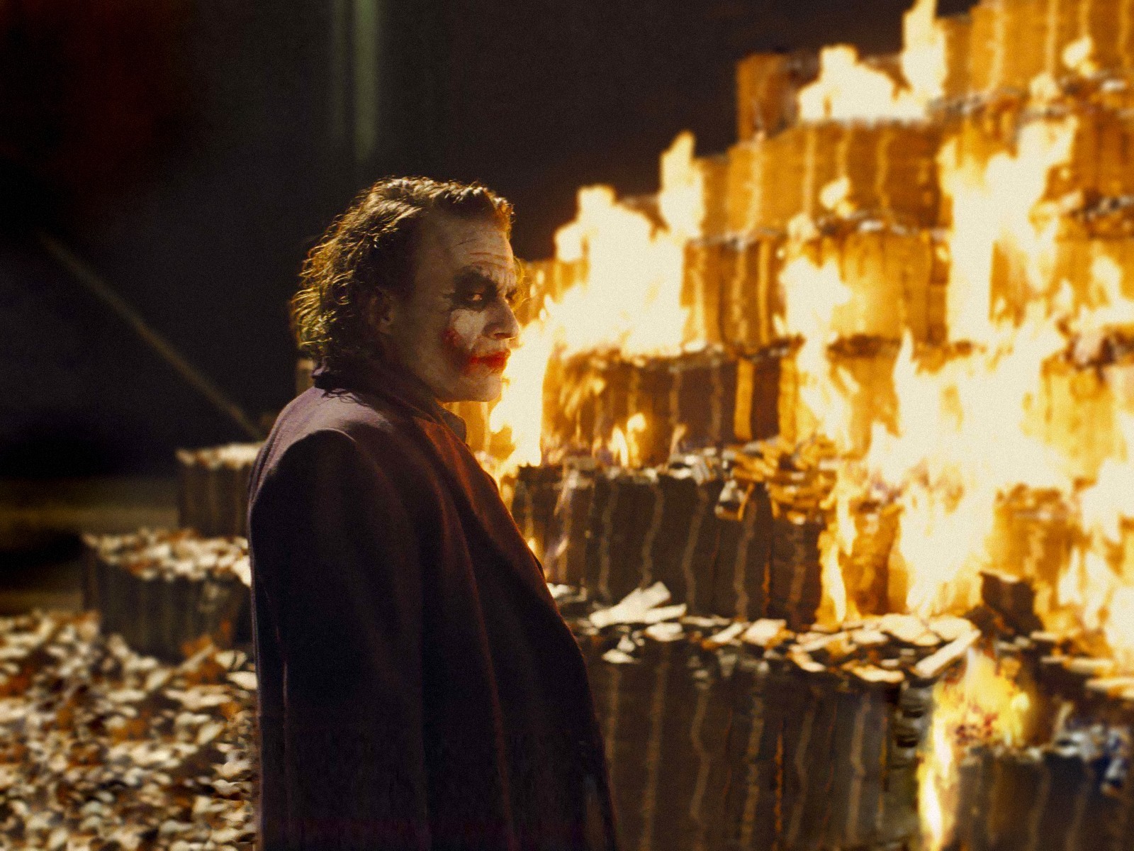 The Joker starts a fire and burns pile