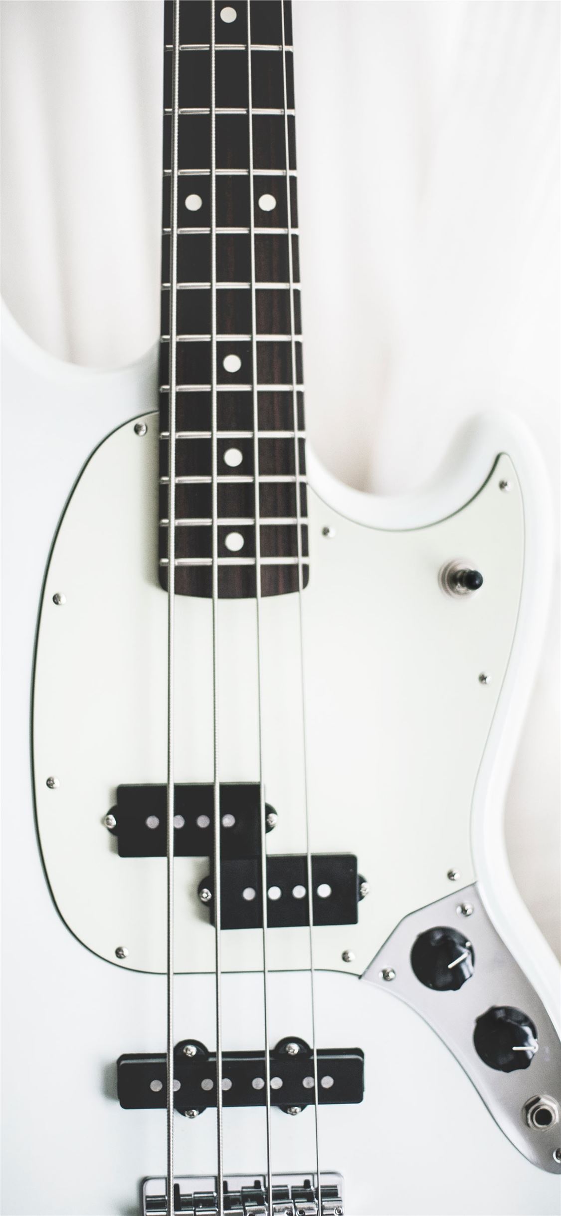 white and black electric bass guitar