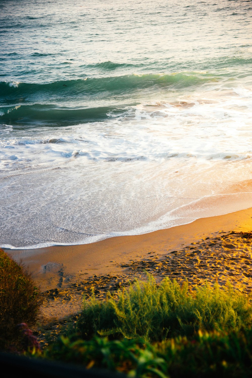 A view of a beach with waves coming