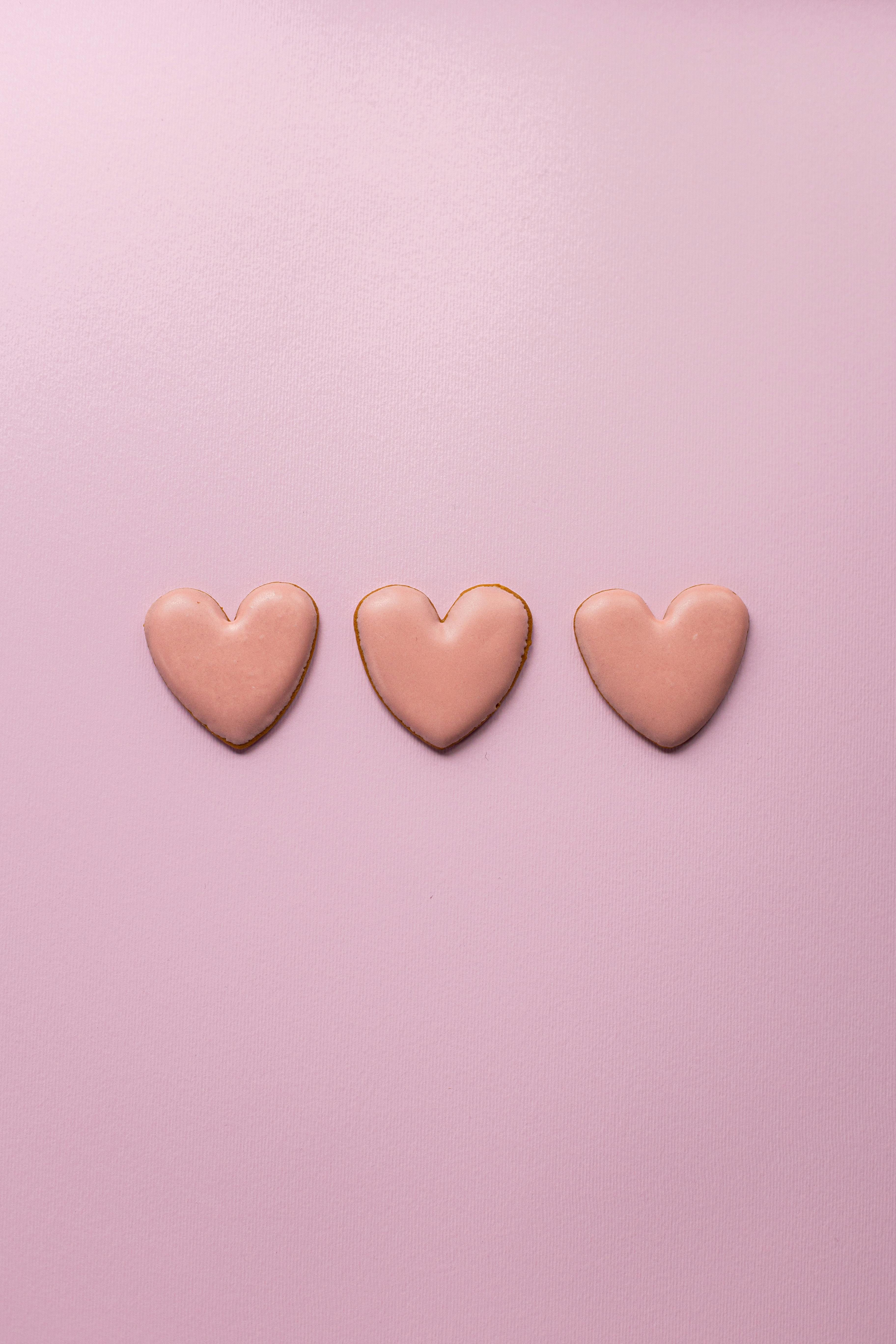 Small heart cookies on pink surface