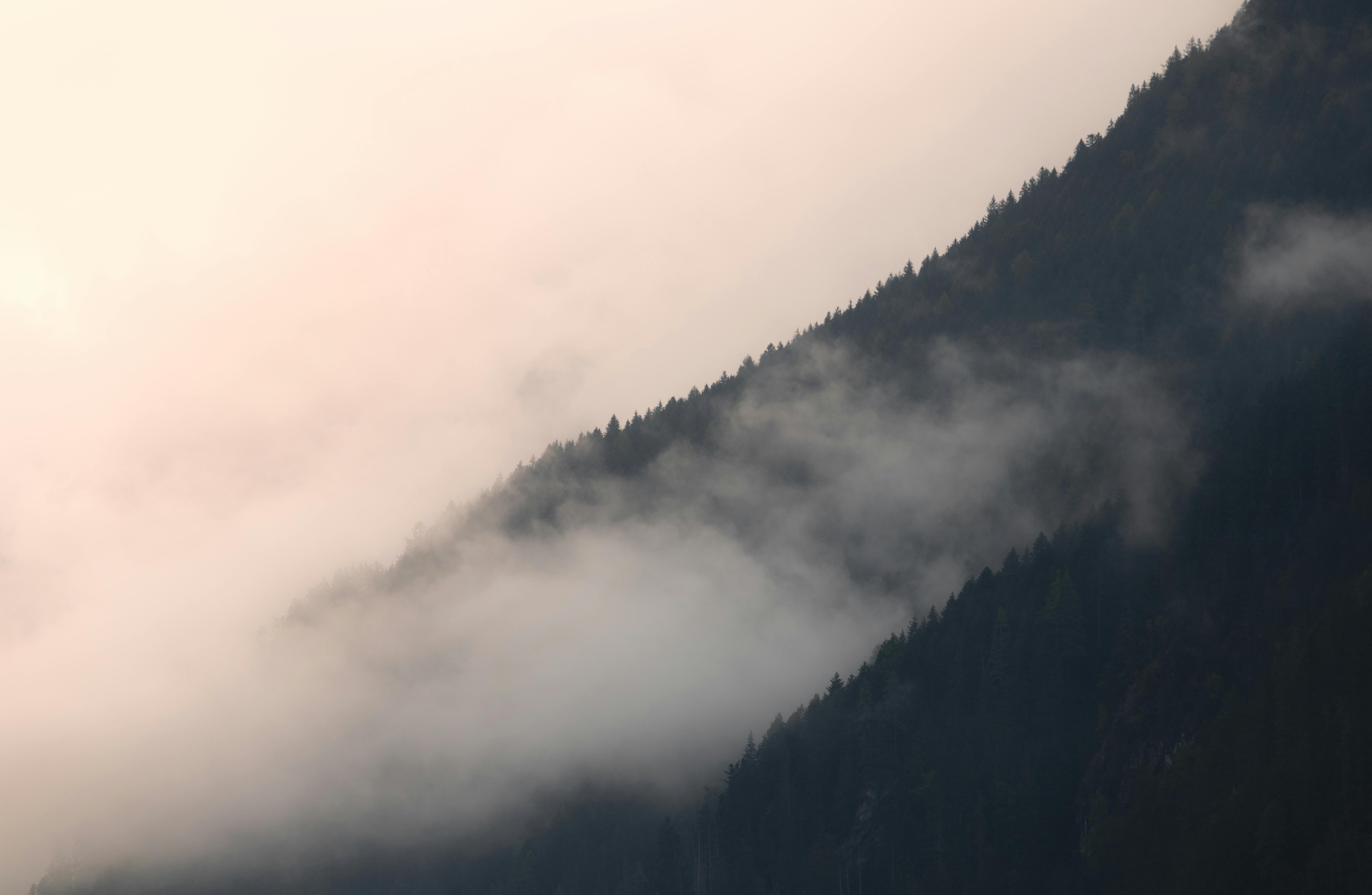 A mountain range with clouds and fog