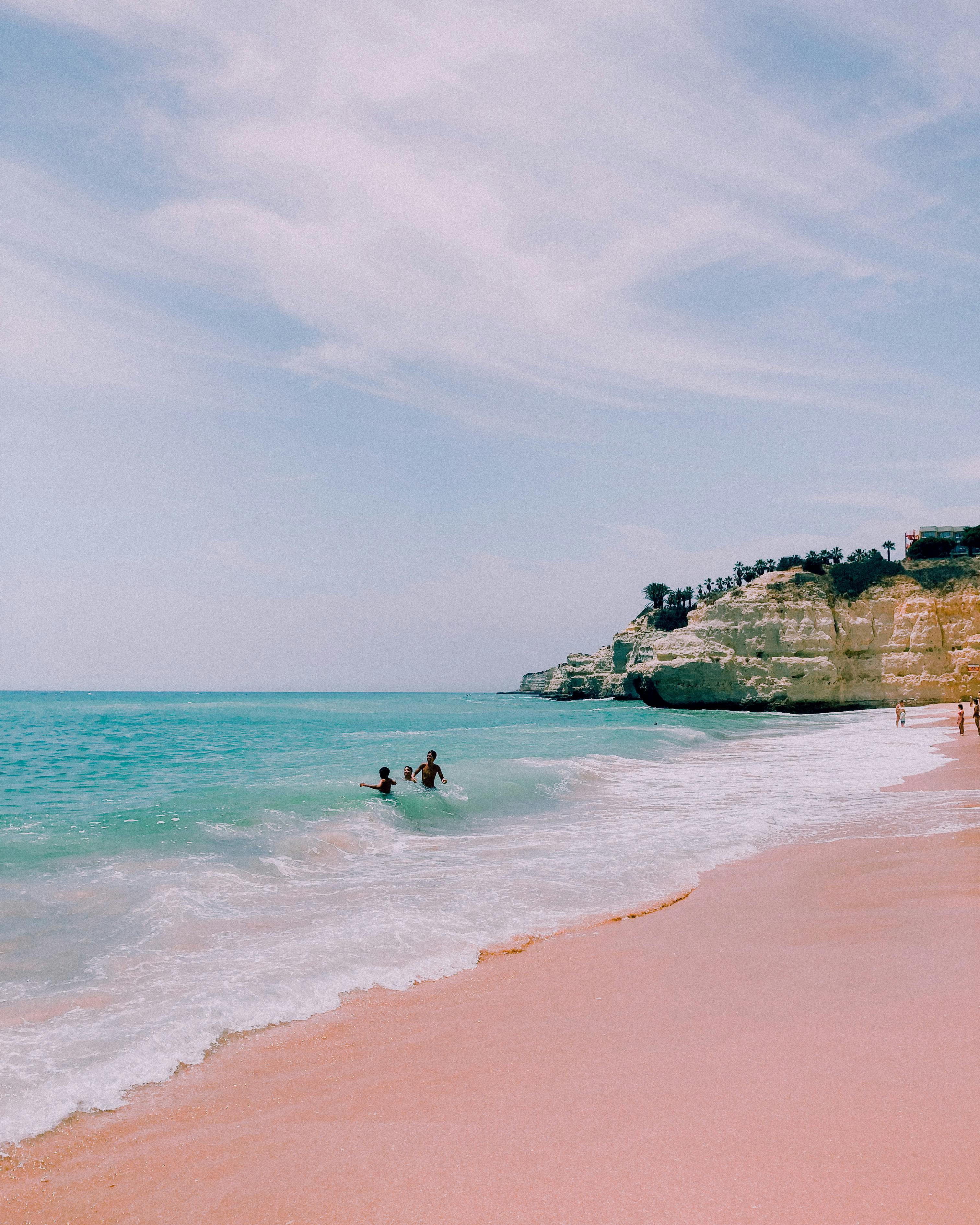 People Swimming on the Beach Near