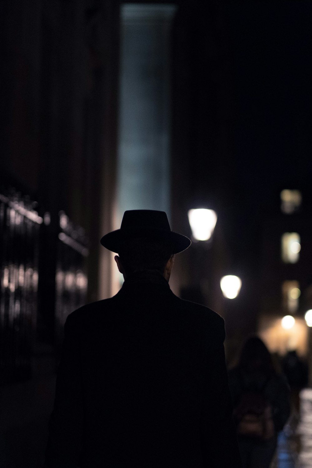Man in black hat walking on sidewalk