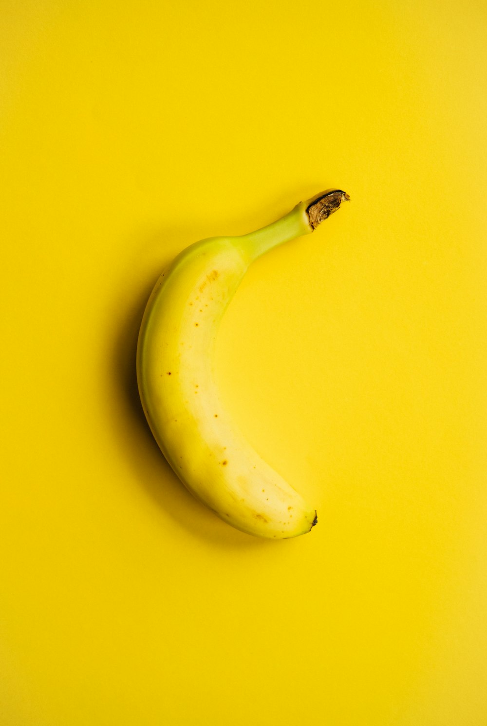 Yellow banana fruit on yellow surface