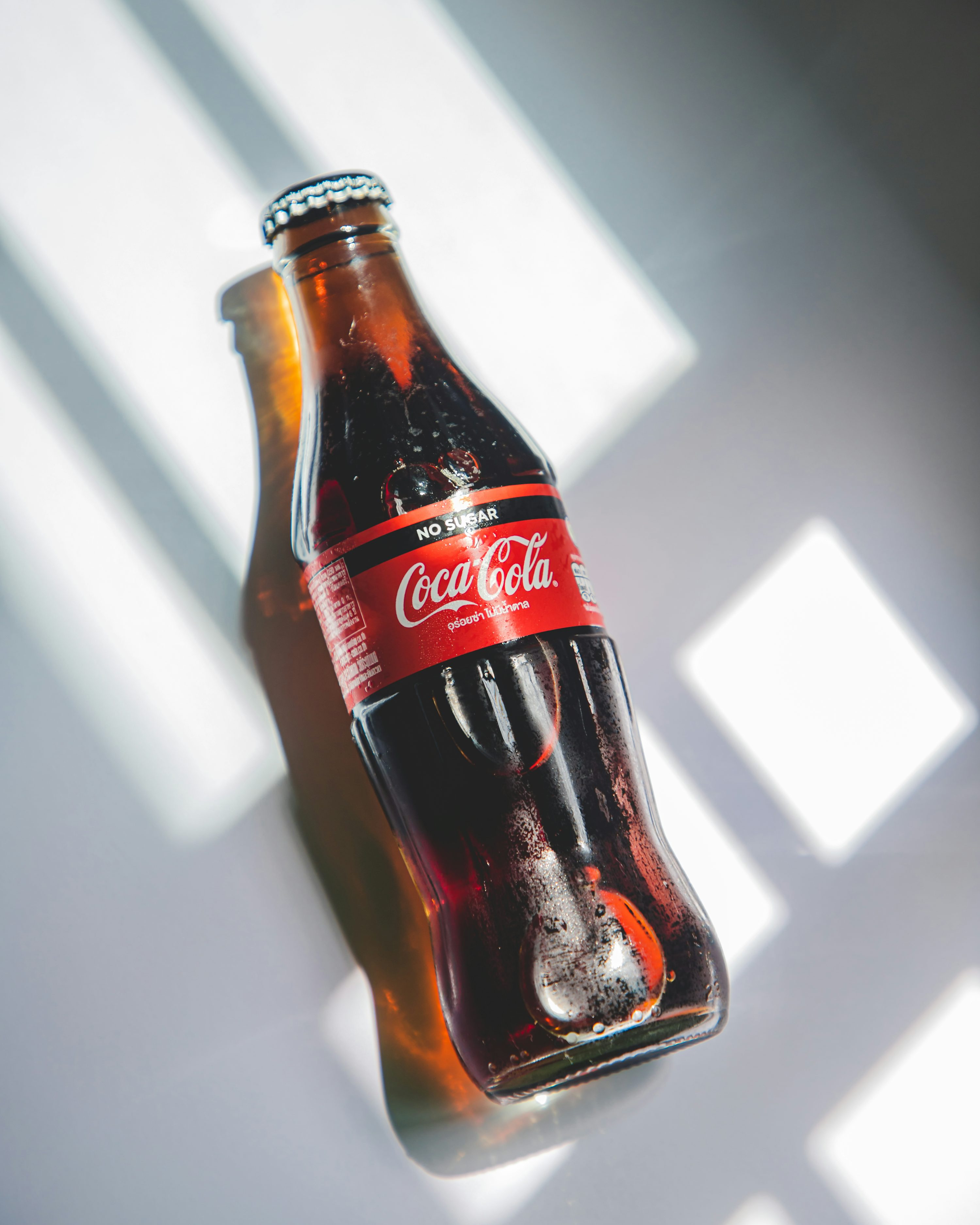 Coca cola bottle on white table photo