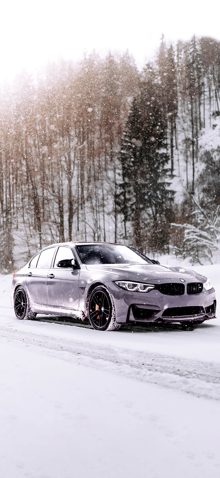 Gray BMW on snowy road 4K Phone Wallpaper