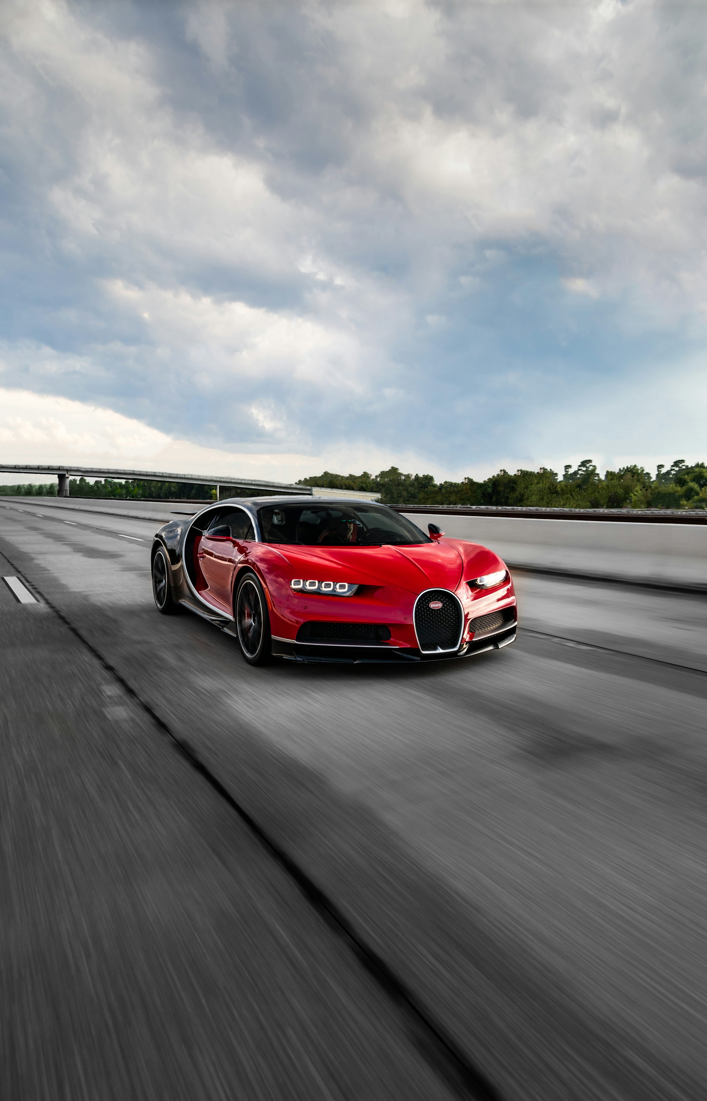 A red bugatti driving down a highway
