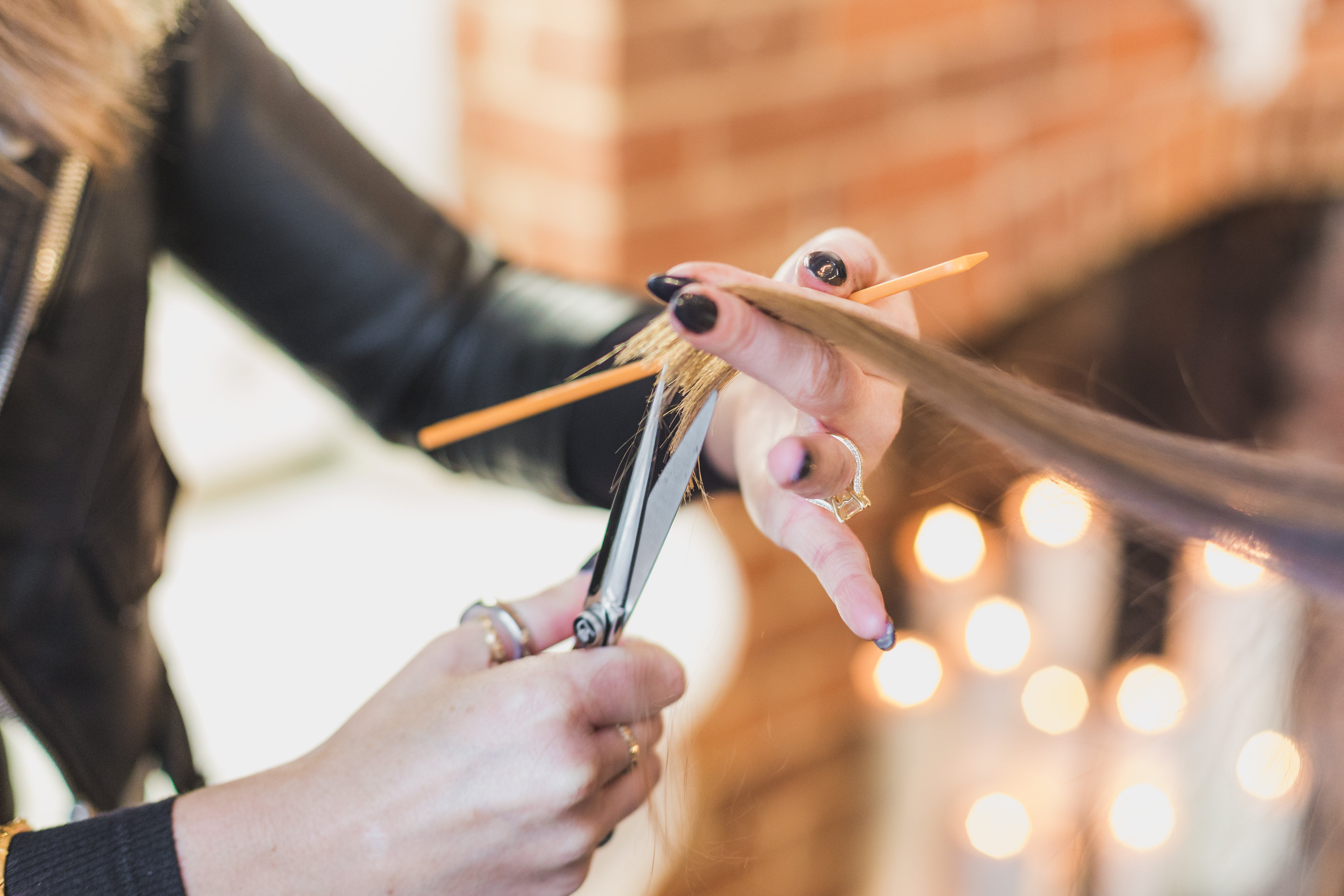 High Res Woman Stylist Cuts Hair At